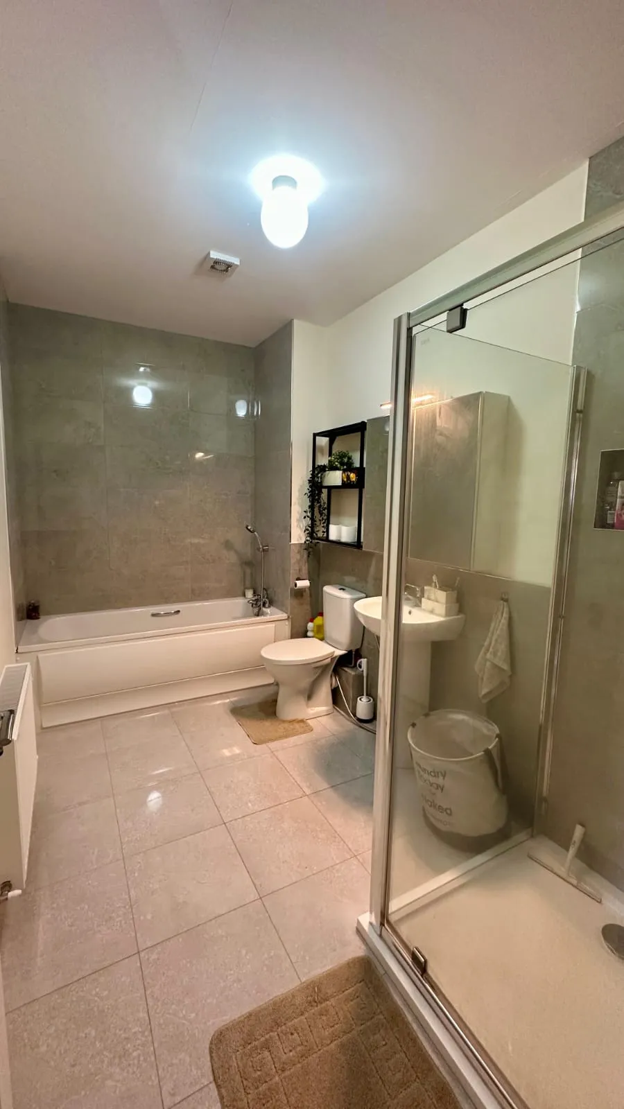 Bathroom with bathtub, separate glass shower, toilet, pedestal sink, mirrored cabinet and shelving