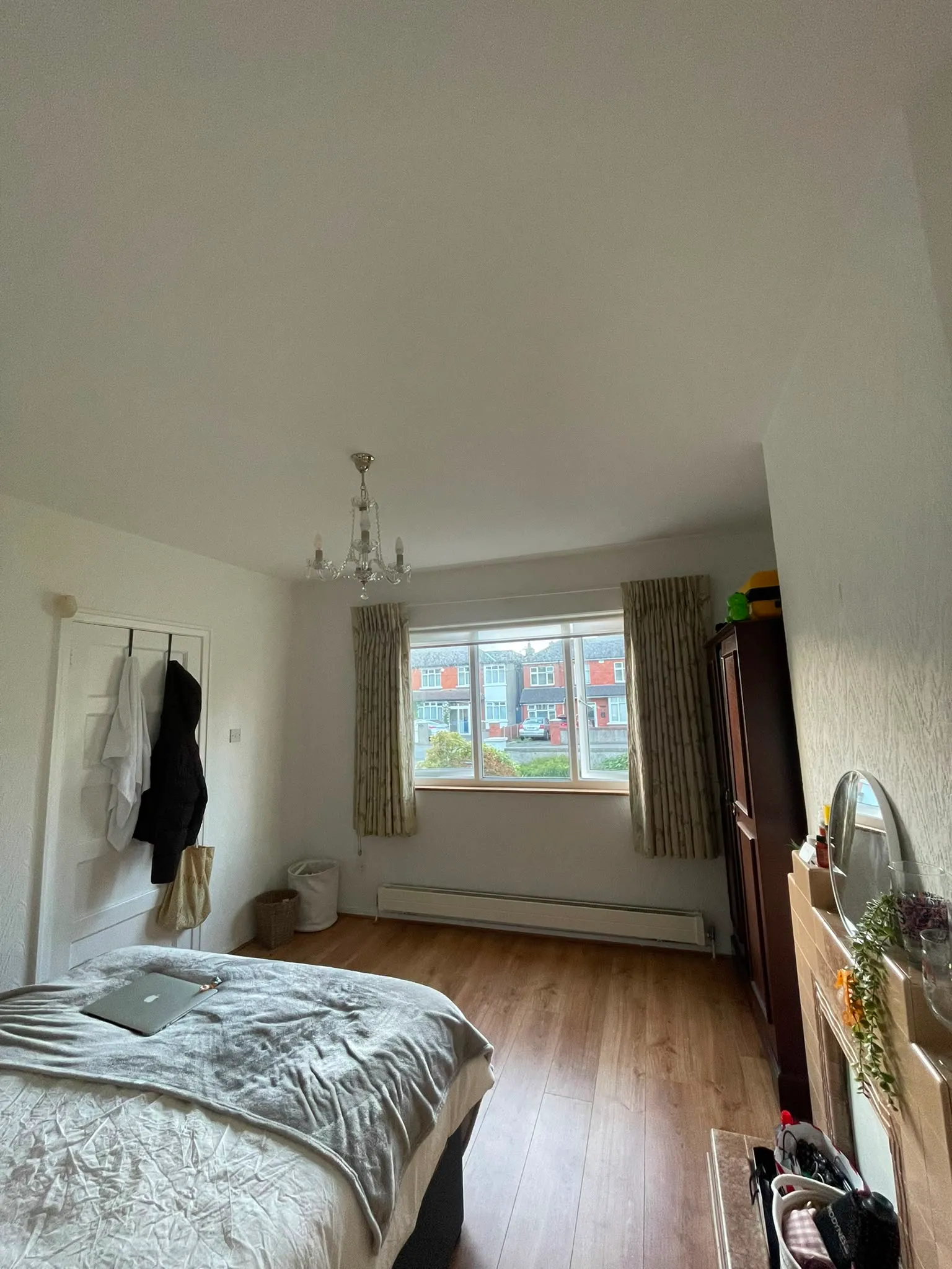 Bedroom with a bed, window with curtains, a chandelier, wardrobe, and hardwood floor