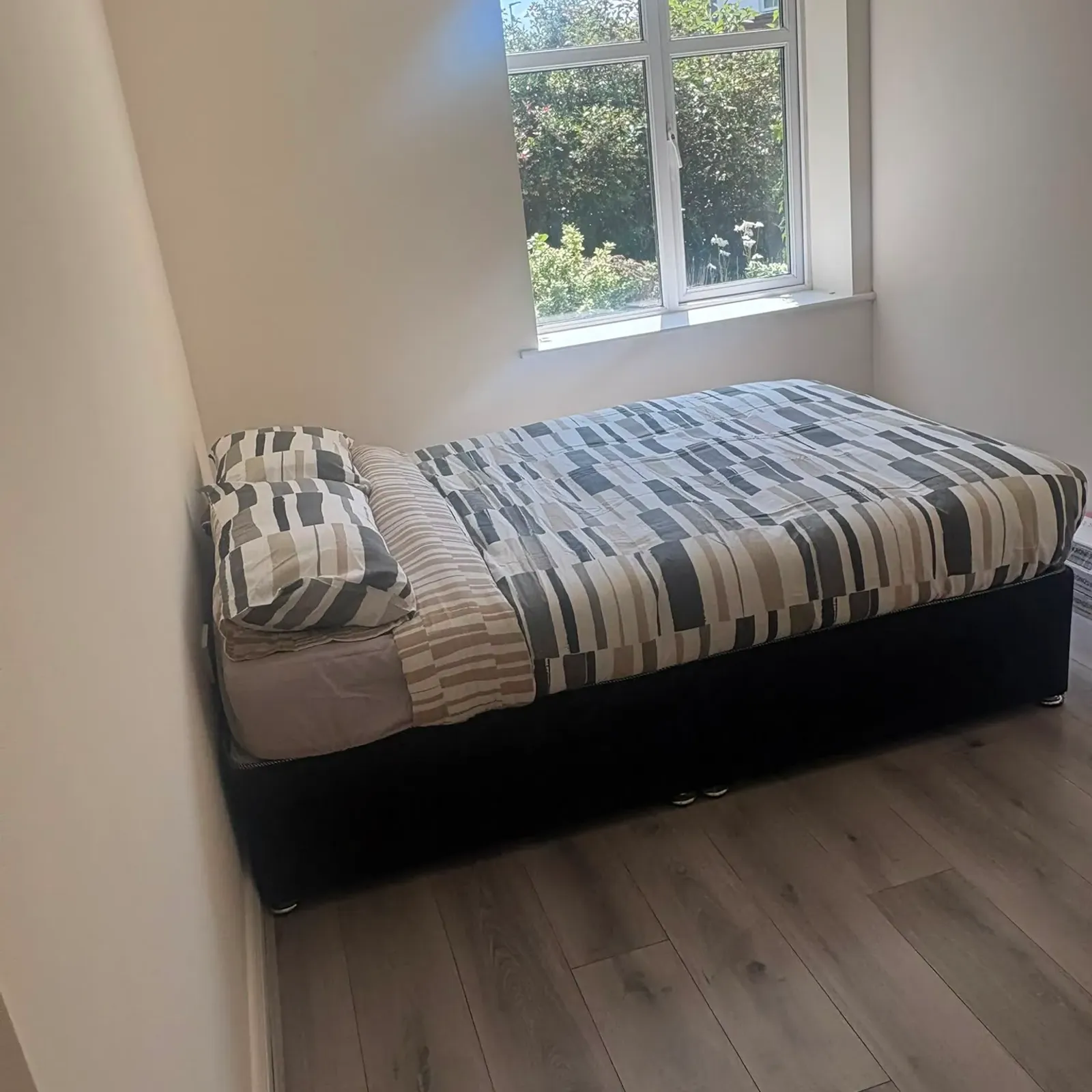 Bedroom with a single/double bed next to a window and wood-look floor