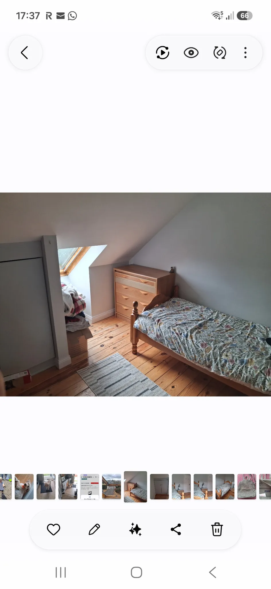 Bedroom with a single wooden bed, patterned bedding, wooden chest of drawers, sloped ceiling and a skylight window, hardwood floor and a small rug.