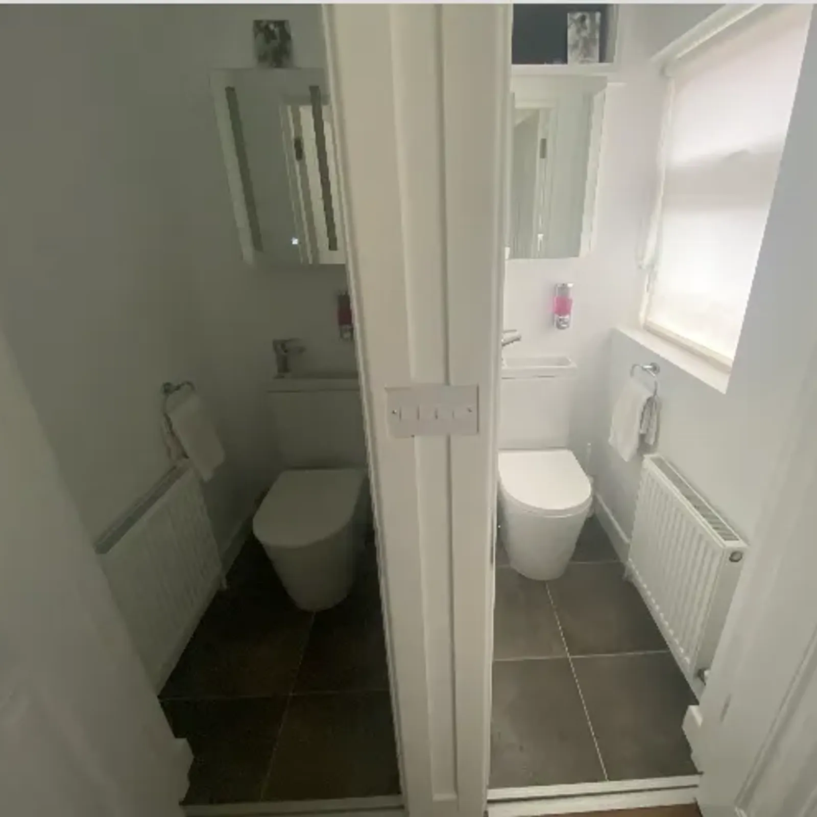 Small bathroom with a toilet, wall mirror, radiator and a window with a blind